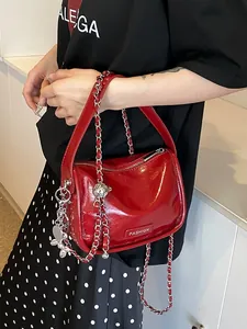 Glossy red patent leather crossbody bag with silver chain strap and rabbit charm
