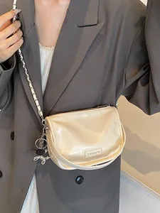 Cream patent leather crossbody bag with chain strap and silver balloon dog charm