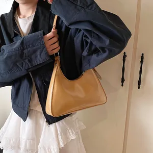 Detail view of the warm brown PU leather shoulder bag with adjustable strap and metal hardware