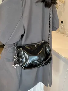 Minimalist black glossy wrinkled crossbody bag with chain strap and balloon dog charm