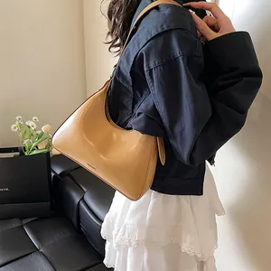 Detail view of yellow leather hobo bag with embossed NO FILTER text worn by a model