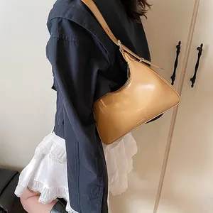 Close-up of camel leather hobo bag with glossy finish and delicate brand logo detail