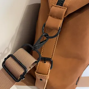 Detail of durable brown fabric with matte black metal hardware and reinforced stitching