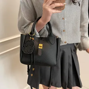 Détail du sac à main en cuir grainé noir avec fermoir doré et logo RAN YOR embossé