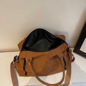 Detail view of large brown travel bag interior with black lining and durable zippers