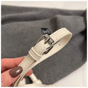 Vue détaillée de la sangle en cuir blanc cassé avec boucle de réglage en métal argenté