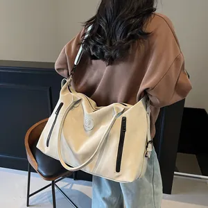 Rear view of model carrying a minimalist beige large capacity travel tote with side zippers