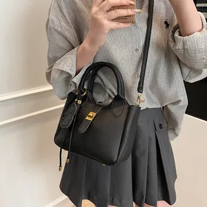 Détail du sac seau en cuir grainé noir avec logo FAN TOR et breloque Kuromi stylée