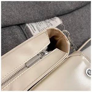 Détails macro d'un sac en cuir beige montrant la fermeture éclair et la doublure brune