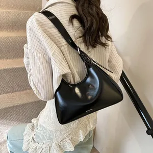 Detail of glossy black shoulder bag featuring NO FILTER print and adjustable metal strap buckle