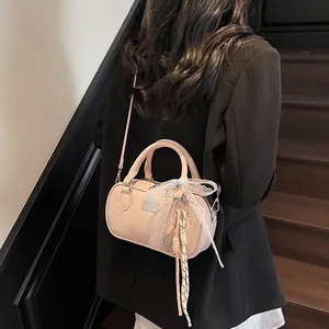 Model wearing a pink bowling bag with lace bow and tennis racket charm on wooden stairs
