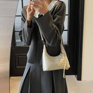 Mirror selfie showing the white crescent moon leather shoulder bag with senajia engraving