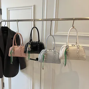 Detail view of colorful Boston bags with bear charms and woven straps in a trendy style
