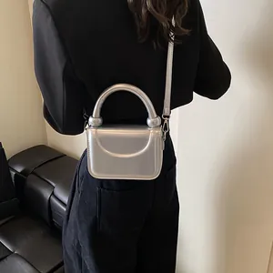 Détail du mini sac à main argenté métallisé avec poignée épaisse et finition miroir