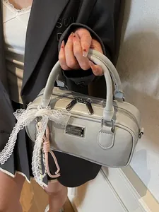 Vintage green bowling handbag with lace bow detail held by model in minimalist setting