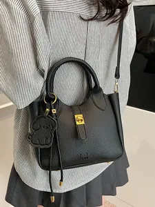 Sac seau chic en cuir grainé noir avec charme de chiot et détails dorés