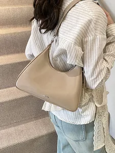Minimalist apricot leather underarm bag with NO FILTER text shown in a lifestyle setting