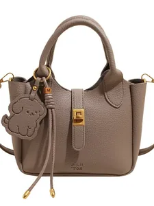 Sac seau en cuir taupe à grain lychee avec fermoir doré et breloque petit chien