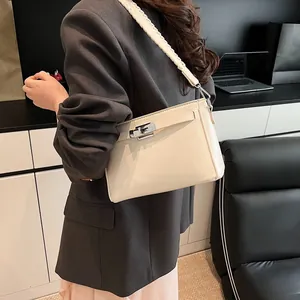 Detailed view of cream leather shoulder bag featuring woven strap and silver clasp