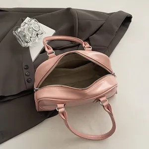 Pink glossy bowling handbag for women with dual top handles and spacious interior