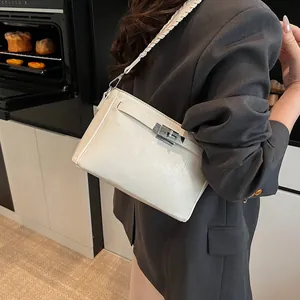 Detail of cream leather shoulder bag with silver turn-lock and woven strap detail