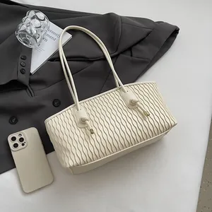 Detail of off-white shoulder bag featuring wavy pleated texture and slim straps