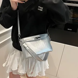 Detail showing metallic silver textured mini bag with silver-tone twist-lock closure