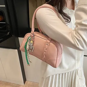 Pink glossy leather Boston bag detail featuring a rhinestone bear and braided rope charm