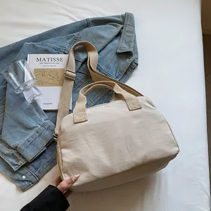 Macro detail of beige canvas bag with adjustable strap and reinforced handles