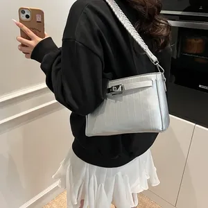 Detail view of silver Kelly bag featuring metallic bark texture and swivel lock closure