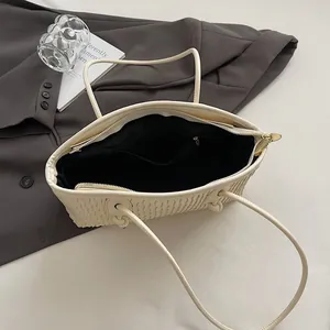 Detailed interior of a cream wave-textured tote bag with black lining and a zipper pocket