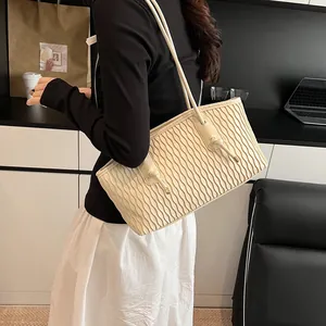 Detail of cream wavy texture tote bag featuring slender shoulder straps and knot design