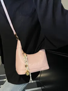 Pink crescent shoulder bag in glossy faux leather with embossed logo and metal charm