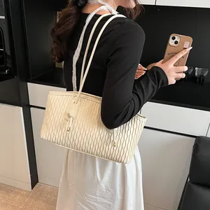 Detail of off-white pleated shoulder bag with wavy texture and drawstring bow detail