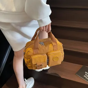 Close-up of yellow nylon crossbody bag with functional multi-pockets and metal zippers