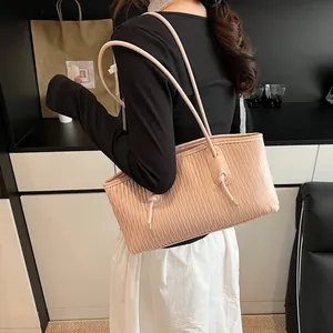 Detail of light pink tote bag featuring unique wave pleats and knotted shoulder straps