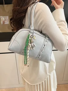 Blue Boston shoulder bag for women with woven detail and bear charm in lifestyle setting