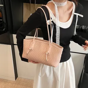 Detail of light pink tote bag featuring unique wavy pleats and elegant knotted strap
