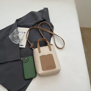 Vue détaillée de haut d'un sac seau minimaliste crème et marron avec lettrage mode