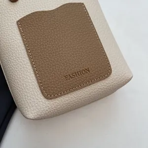 Gros plan du sac seau en cuir grainé avec détail de poche marron embossée mode