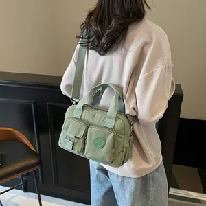 Detail of light green multi-pocket commuter bag with adjustable shoulder strap and soft texture
