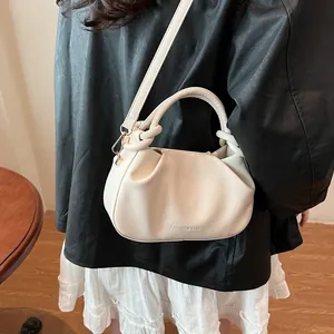 Detail of creamy white pleated crossbody bag with Fashion & Bags text on soft leather
