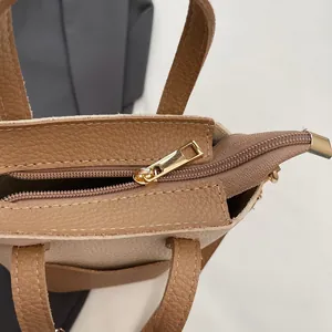 Vue détaillée du sac seau en cuir marron motif litchi avec fermeture éclair dorée