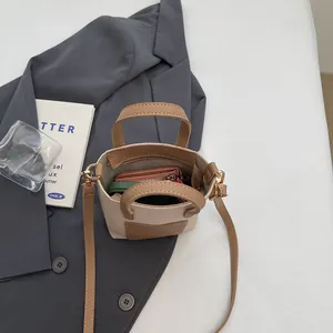 Vue de dessus du sac seau bicolore montrant l'intérieur spacieux avec portefeuille rose et cuir