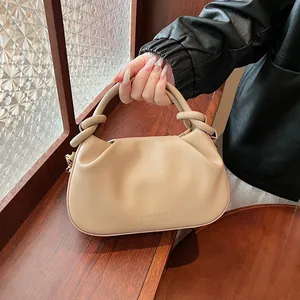 Detail of beige pleated leather handbag with knot handle and Fashion & Bags text