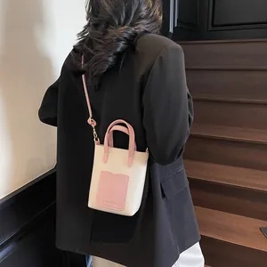 Vue arrière du sac seau bicolore minimaliste avec bandoulière rose contrastée