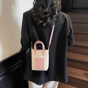Gros plan détaillé d'un mini sac seau beige et rose avec lettrage FASHION