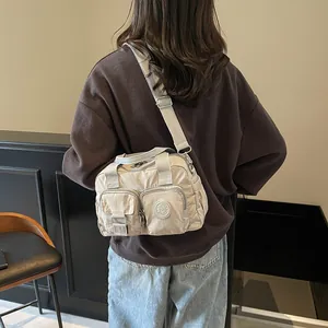 Detail showing high-quality nylon texture and dual zip pockets of the grey crossbody bag