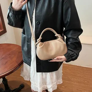 Detail of beige pleated cloud bag with knotted top handle and fashion logo lettering