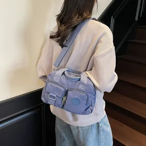 Detailed close-up of blue nylon multi-pocket crossbody bag with adjustable wide strap